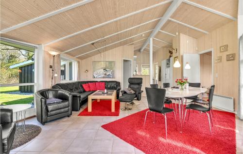 a living room with a couch and a table and chairs at Holiday Home Frankelund Tranekær Ii in Hou