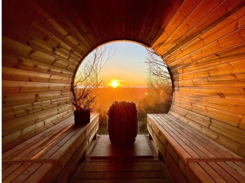 a wooden sauna with a sunset in the background at Lynæs Surfcenter in Hundested