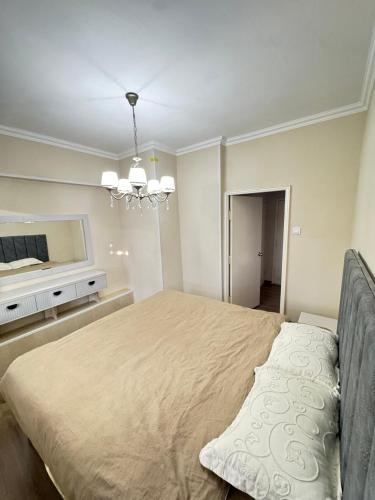 una camera da letto con un letto grande e un lampadario di Anisa Apartment a Tashkent