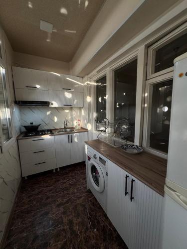 una cucina con lavatrice e lavandino di Anisa Apartment a Tashkent