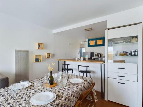 une cuisine avec une table avec des assiettes dessus dans l'établissement À 200m de la plage, appartement pour 4, à Plage-des-Demoiselles