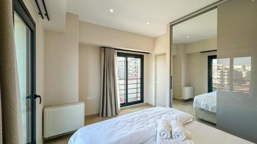a bedroom with two beds and a large window at VILLA 8 By ProLiving Hospitality in Thessaloniki