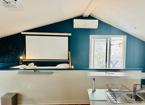 une cuisine avec un mur bleu et une fenêtre dans l'établissement Merveille du temple, à Bordeaux