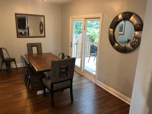 a dining room with a table and chairs and a mirror at The House Hotels - W45th Backhouse in Cleveland