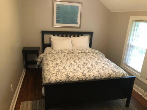 a bed with a black frame and a bed sidx sidx sidx sidx sidx at The House Hotels - W45th Backhouse in Cleveland