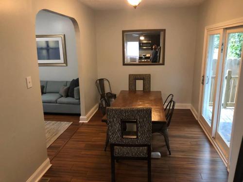 a dining room with a table and chairs and a couch at The House Hotels - W45th Backhouse in Cleveland