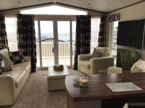 a living room with a couch and a table at Newquay Haven caravan 42x14 with Ocean Views in New Quay