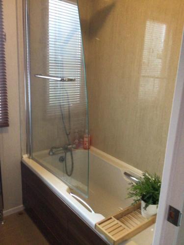 a shower with a glass door in a bathroom at Newquay Haven caravan 42x14 with Ocean Views in New Quay