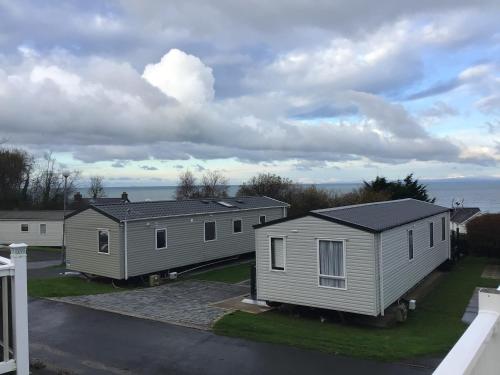 a row of modular homes with the ocean in the background at Newquay Haven caravan 42x14 with Ocean Views in New Quay