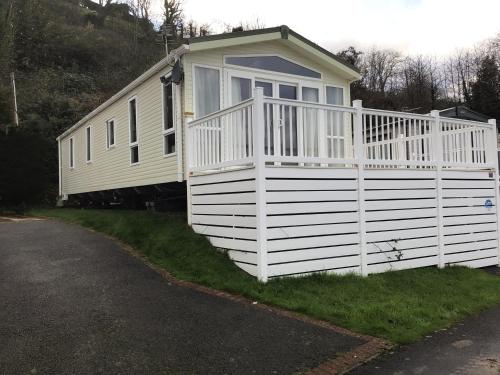 a large white house with a white fence at Newquay Haven caravan 42x14 with Ocean Views in New Quay