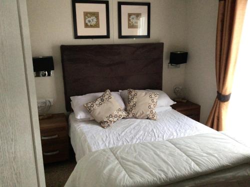 a bedroom with a bed with pillows on it at Newquay Haven caravan 42x14 with Ocean Views in New Quay