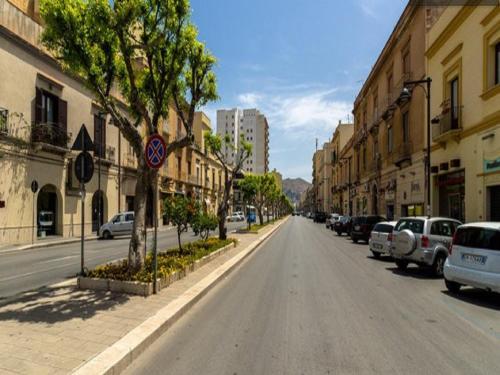 an empty street in a city with parked cars at Fardella 250 in Trapani