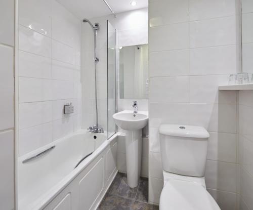 a white bathroom with a toilet and a sink at Leonardo Inn Glasgow West End in Glasgow