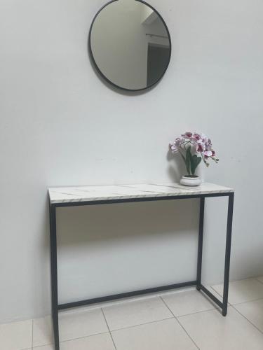 a console table with a mirror on a wall at Orked Home2stay in Tampin