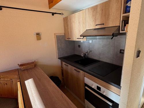 Il comprend une petite cuisine avec un évier et un comptoir. dans l'établissement Appartement cosy, 6 pers, 2 chambres, mezzanine, balcon sud, ski, La Chapelle-d'Abondance - FR-1-692-82, à La Chapelle-dʼAbondance