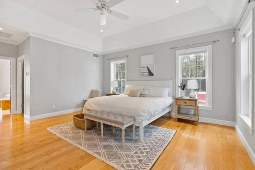 a white bedroom with a bed and a table at Lakefront Moose Pond Retreat in Denmark