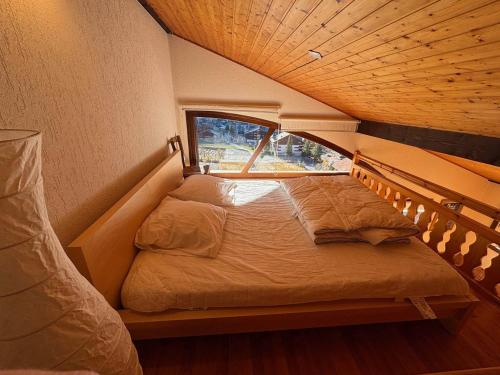 ein Bett in einem kleinen Zimmer mit einer Treppe in der Unterkunft Spacieux appartement 2 chambres avec balcon ensoleillé - FR-1-692-82 in La Chapelle-dʼAbondance