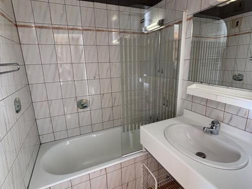 ein weißes Badezimmer mit Waschbecken und Badewanne in der Unterkunft Spacieux appartement 2 chambres avec balcon ensoleillé - FR-1-692-82 in La Chapelle-dʼAbondance