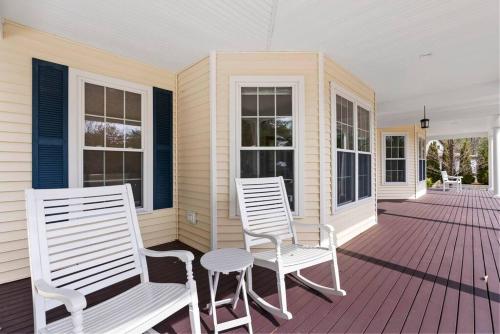 two white chairs and a table on a porch at Lakefront Moose Pond Retreat in Denmark