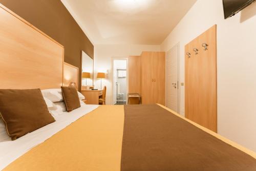 a bedroom with a large bed with a wooden headboard at Hotel Eden Salò in Salò