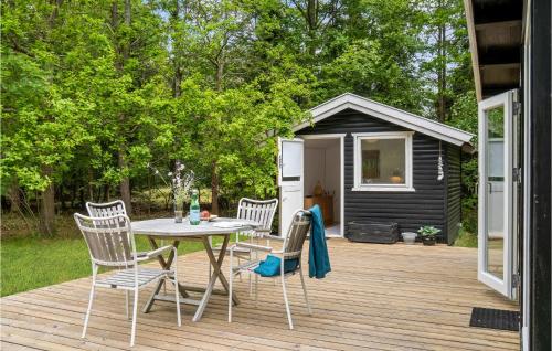 a wooden deck with a table and chairs and a shed at Amazing Home In Rørvig With Kitchen in Rørvig