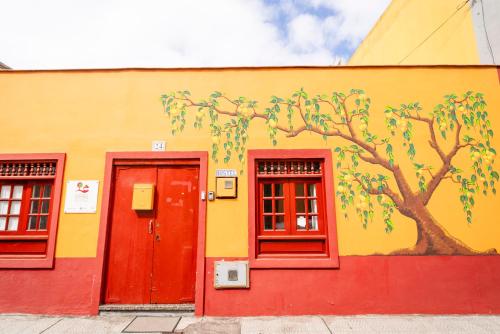 a building with a tree painted on the side of it at Hostel Tenerife in La Orotava