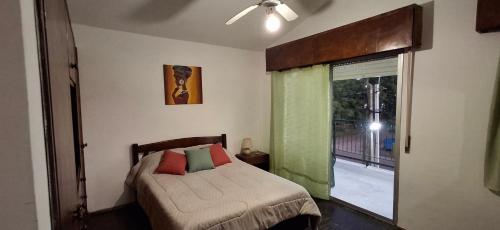 a bedroom with a bed and a sliding glass door at Hermoso apartamento en el centro de Atlántida in Atlántida