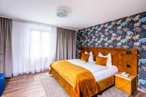 a bedroom with a large bed with a yellow blanket at Gästehaus Klinglhuber in Krems an der Donau