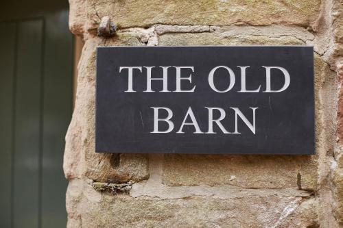 a sign that reads the old barn on a brick wall at The Duncombe Arms in Ellastone