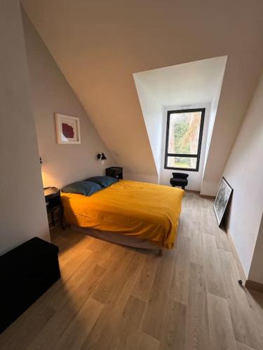 - une chambre mansardée avec un lit jaune dans l'établissement Maison moderne et chaleureuse, emplacement idéal, à Arzon