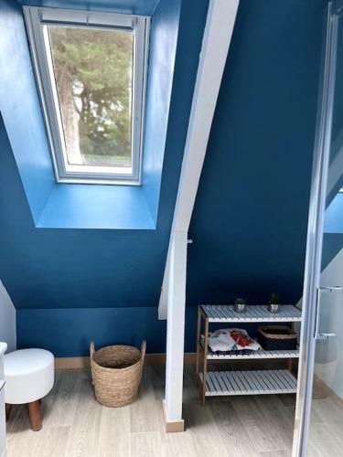 La salle de bains est pourvue d'un mur bleu et d'une fenêtre. dans l'établissement Maison moderne et chaleureuse, emplacement idéal, à Arzon