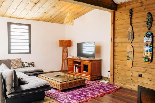 a living room with a couch and a tv at Ti Kaz - 6 voyageurs in LʼEntre-Deux