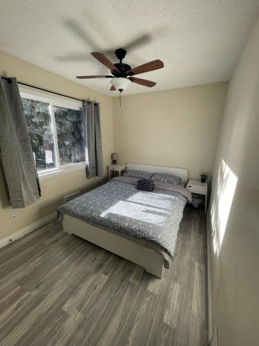 a bedroom with a bed and a ceiling fan at UofC-SAIT-Banff Trail-Suite A&B in Calgary