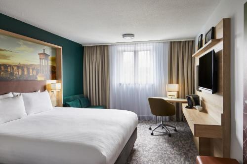 a hotel room with a bed and a desk at Leonardo Hotel Edinburgh Haymarket in Edinburgh