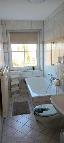 ヨハンジョルゲンシュタットにあるFerienwohnung Bergluftの浴槽と洗面台と窓のあるバスルーム