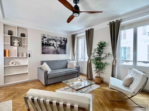 un salon avec un canapé et un ventilateur de plafond dans l'établissement Typical Luxurious Parisian Getaway, à Paris