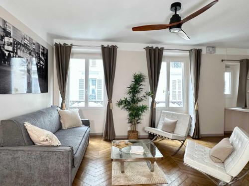 un salon avec un canapé et un ventilateur de plafond dans l'établissement Typical Luxurious Parisian Getaway, à Paris