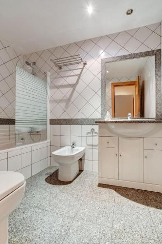 a bathroom with a sink toilet and a mirror at A1 Outra Vez - Spacious apartment in Carvoeiro