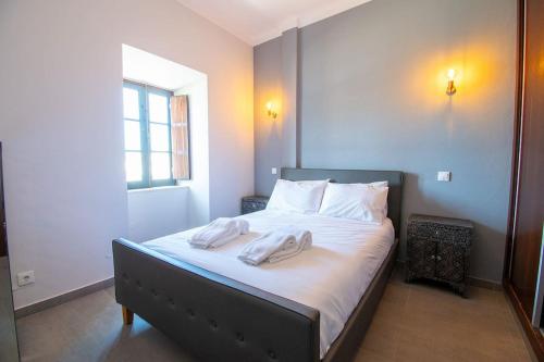 ein Schlafzimmer mit einem Bett mit zwei Handtüchern darauf in der Unterkunft 12a Travessa da Nau - Modernised yet traditional in Carvoeiro