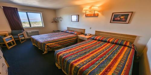 a hotel room with two beds and a window at Super 8 by Wyndham Lake Havasu City in Lake Havasu City