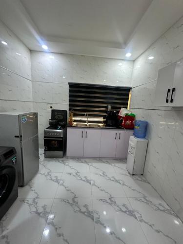 a kitchen with a white tiled floor and a stove at Exotic 2Bedroom duplex in ogudu in Lagos