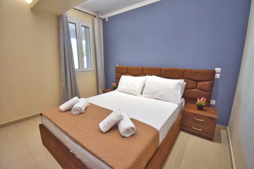 科孚镇Alykes Houses - Prv Jacuzzi的卧室里有一张大床，床上铺着毛巾。