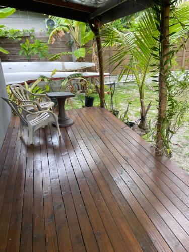a porch with a table and chairs on a wooden deck at Makalii lodge in Tiputa