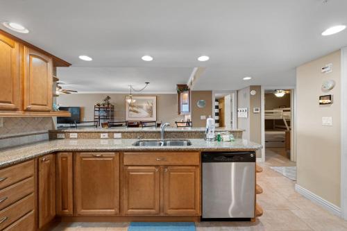 a kitchen with wooden cabinets and a sink at SeaSpray East 624-Gulf Front in Pensacola