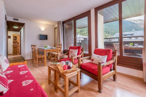 un salon avec un canapé, des chaises et une table dans l'établissement Charming apartment with mountain view, à Chamonix-Mont-Blanc