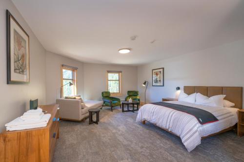 a bedroom with a large bed and a living room at The Lodge at Bow Lake in Lake Louise
