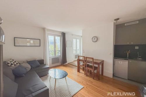 un salon avec un canapé et une table dans l'établissement Flexliving - One bedroom - Houdon, à Paris