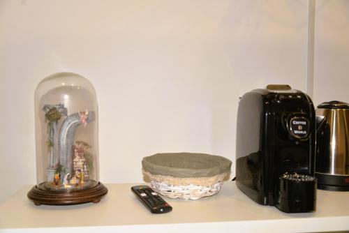 a coffee maker and a clock on a counter at Punto Felice Riviera - Centro Città Lungomare Caracciolo in Naples