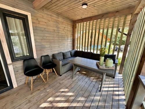 a screened in porch with a couch and chairs at Domki pod Aniołem in Huta