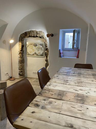 a dining room with a large wooden table and chairs at The Charming House by 1722 in Ville-di-Paraso